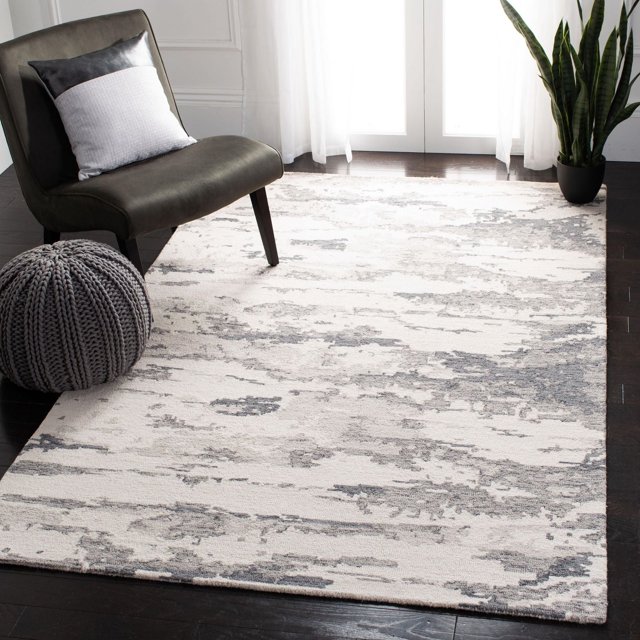 SAFAVIEH Tapis en Laine Abstraite Seachlann à Effet Vieilli avec texture Douce de Laine à Poil en Boucle et Motif Abstrait Vieilli Gris et Crème, Exposé sur Plancher de Bois Franc Foncé dans une Pièce Contemporaine avec une Chaise Rembourrée Gris Foncé, pouf Gris Tricoté et Plante en Pot Verte, Rideaux Blancs Translucides Près, Idéal pour Ajouter de la Chaleur et un Confort Décoratif aux Espaces de Vie.