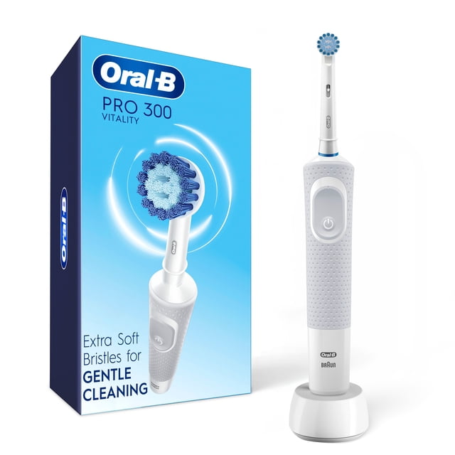 Oral-B Pro 300 Sensitive Clean Vitality Electric Toothbrush in white with one brush head, displayed on its charging base next to its blue packaging. It features extra soft bristles for gentle cleaning, sensitive mode, and 2D oscillating-rotating action for effective plaque removal.
