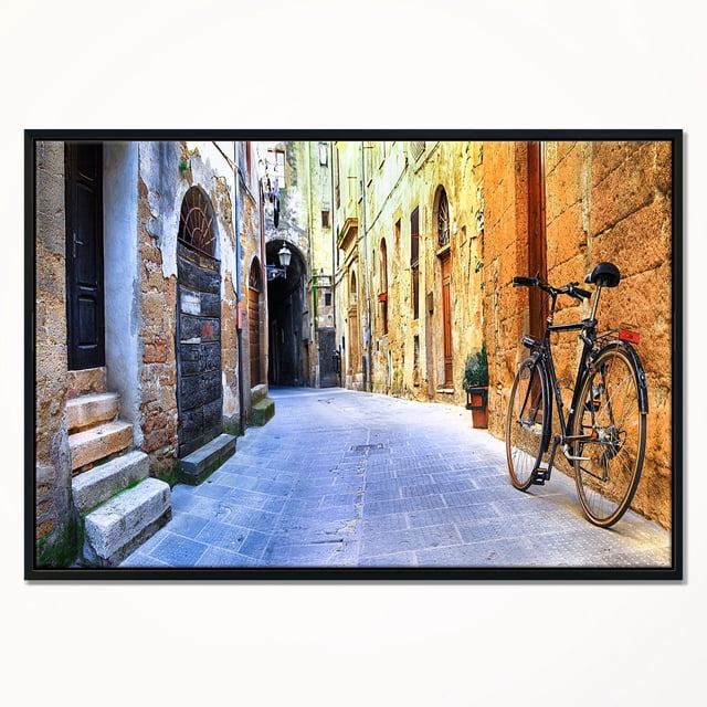 Design Art Rue Picturale de l'Ancienne Italie Impression d'Art sur Toile Encadrée Représentant une Rue Étroite en Galets Bordée de Bâtiments en Pierre Vieillis avec des Portes en Bois Arquées, Mettant en Vedette une Bicyclette vintage Noire Appuyée sur un Mur orange Texturé, Imprimée avec une Encre Résistante à la Décoloration sur Toile de Qualité Supérieure Tendue sur un sous-Cadre en Bois de 1 Po et Enveloppée dans un Cadre Flottant Noir, Prête à Accrocher avec la Quincaillerie Incluse, Convient