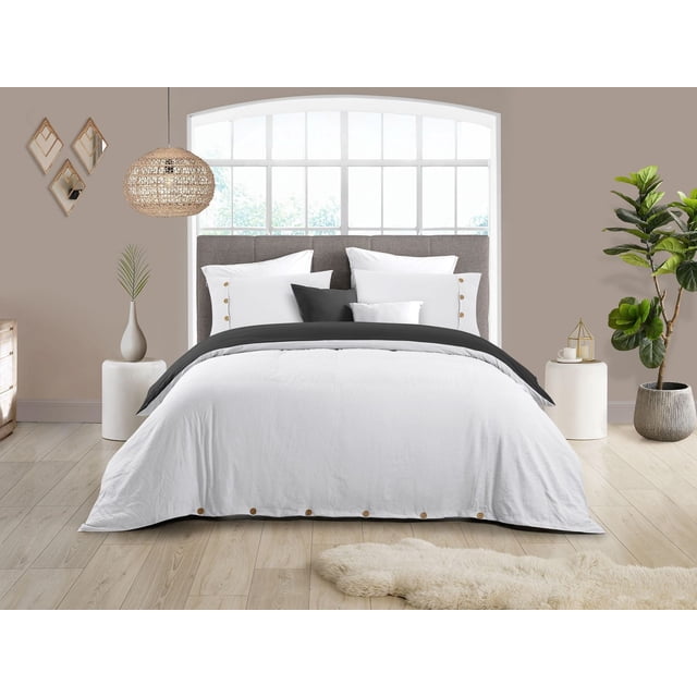 Reversible Natural Crinkle Fabric Ultra Soft Solid Duvet Cover Set in white with dark grey reverse side, featuring button closure along the bottom edge, displayed on a bed with matching pillow shams in a modern bedroom with light wood flooring, neutral walls, woven pendant light, and green plants, suitable for adding softness and style to bedroom decor.