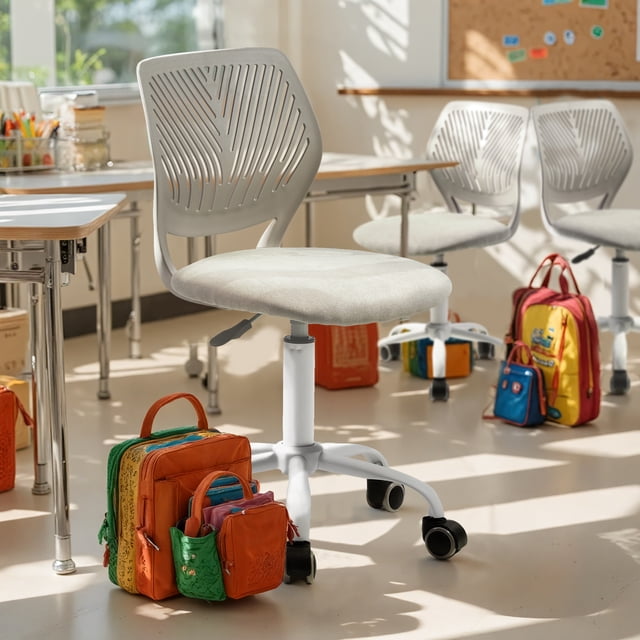 Homy Casa 2 Packs Compact Rolling Desk Chair for Student with a white slim base, ergonomic leaf-design mesh backrest, cushioned light grey fabric seat, height adjustable for desks 28"–30", and black rolling casters, placed in a bright classroom with colorful student backpacks.