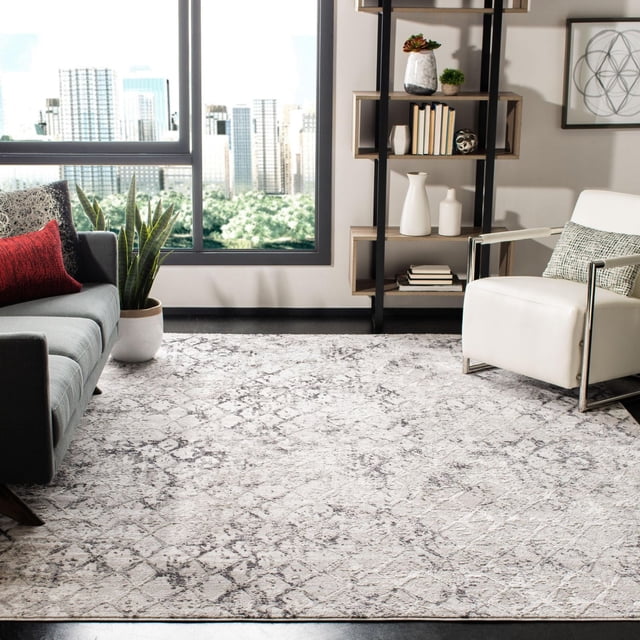 SAFAVIEH Amelia Roslyn Abstract Distressed Area Rug featuring a plush synthetic yarn texture and neutral abstract distressed pattern, placed in a contemporary living room with a grey sofa, red accent pillow, white armchair, large window with city view, and black metal bookshelf with decor, ideal for modern home accents.
