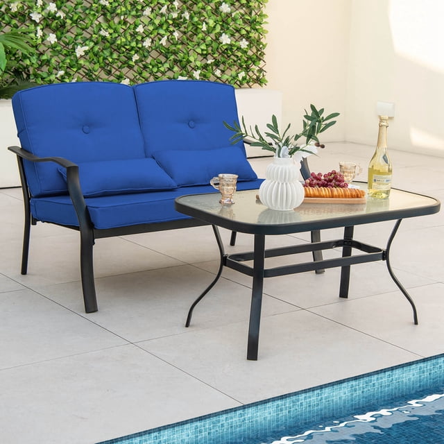 Costway Ensemble de Mobilier de Patio 2 Pcs Comprenant un Causeuse Coussiné Bleu Marine et une table Basse en Métal Noir avec Dessus en Verre Trempé. le Causeuse Comprend des Accoudoirs Courbés et des Coussins Moelleux pour le Confort, pendant Que la table Basse Offre une surface Robuste pour la Nourriture et les Boissons. l'Ensemble Est Exposé au Bord de la Piscine avec des Articles Décoratifs, Mettant en Valeur Sa Convenance pour les Espaces Extérieurs comme les Cours Arrière et les patios.
