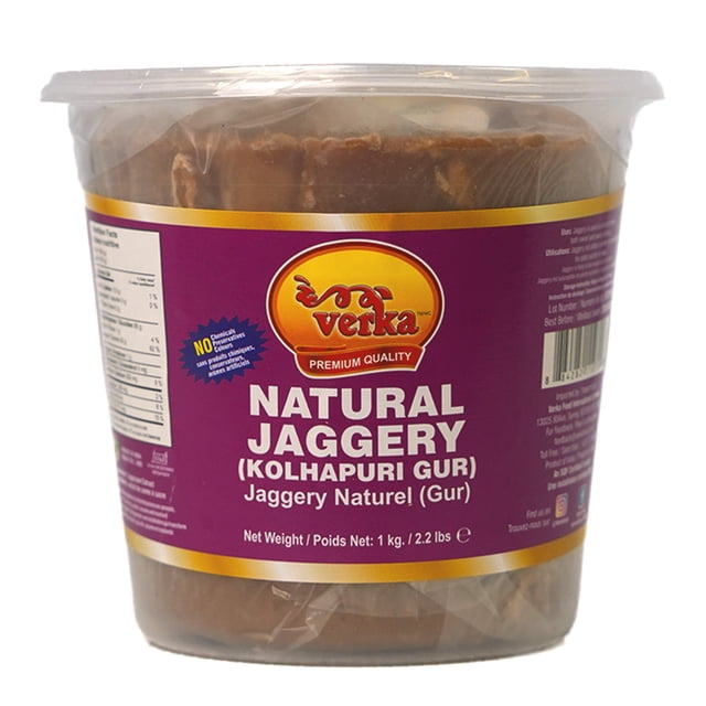 Verka Kolhapuri Gur, 1kg, natural jaggery in a clear plastic container with a purple and gold label displaying the Verka logo and product name, containing dark brown unrefined jaggery used as a traditional brown sugar sweetener and cooking ingredient, also suitable for enriching teas and curries.