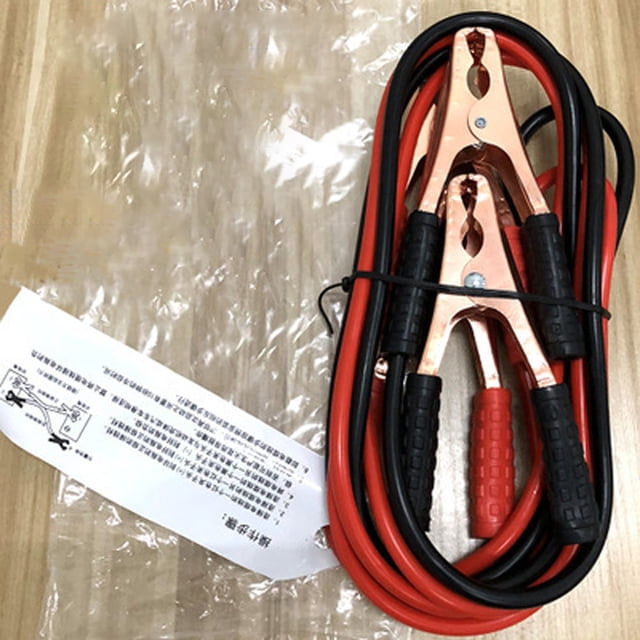3 meter 500A Jumping Cables Gauge Booster Cable Power Jumper Start Cars Auto Black Red. The image shows a set of red and black car jumping cables made from PVC and copper wire, with thick rubber-like insulation for flexibility. The cables are neatly coiled with visible copper clamps and black and red handles, placed on a wooden surface with a plastic bag and instruction sheet nearby.