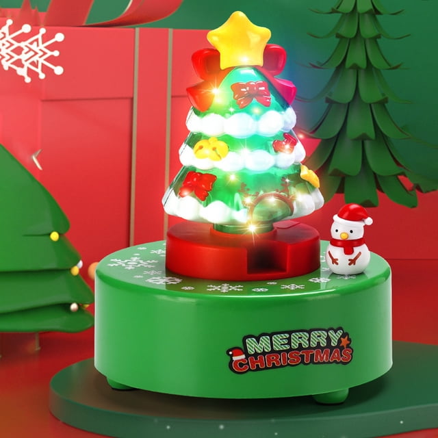 Christmas Tree Toy Sets, a multicolour crystal ball music box with a mini illuminated Christmas tree that rotates 360 degrees. Includes a snowman figurine on a green base with 'Merry Christmas' text. Perfect as an indoor Christmas decoration or snow globe-style holiday gift for kids.