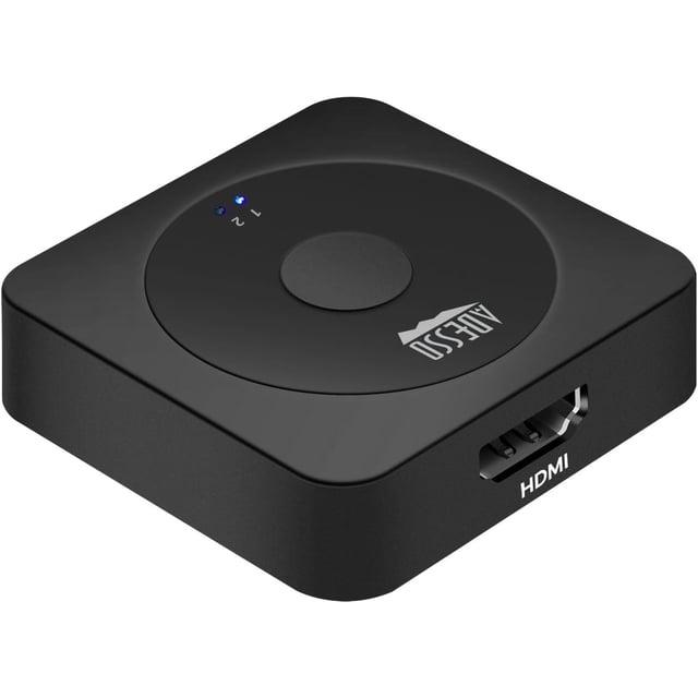 Adesso 2-Port HDMI Switch AUH-5100, compact black square device with rounded corners, central manual switch button, two blue LED indicators labeled 1 and 2, and a gold-plated HDMI port on the side, supporting 4K 60Hz resolution and HD audio passthrough, suitable for easily switching between multiple HDMI devices on one screen.