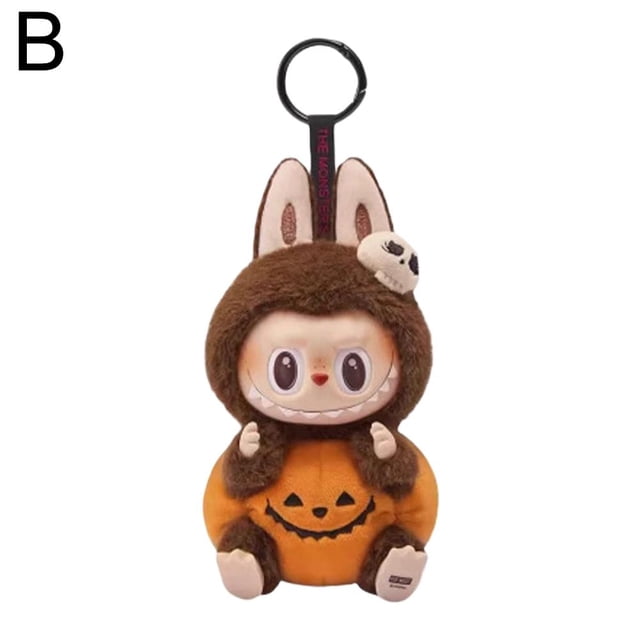 Plush Toy with Resin Details - 17cm, Soft and Cuddly. A 17cm plush toy designed with a Halloween-inspired pumpkin outfit in orange and brown, featuring resin accents and a whimsical face with large eyes and a playful grin. Includes a keychain loop for easy attachment, making it ideal for collectors or as a decorative accessory. Crafted from soft plush material for comfort and durability.