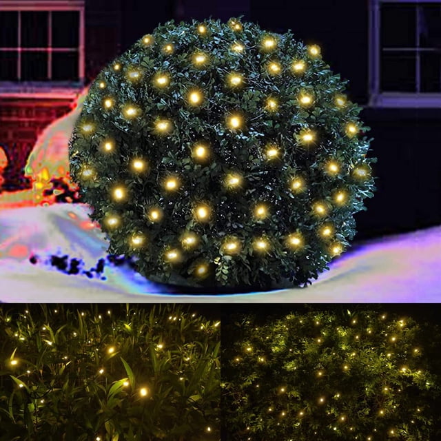 LED Christmas net lights outdoor decorations for bushes, featuring 96 warm white LEDs on a 5ftx5ft green wire mesh. The lights are displayed on a shrub in a nighttime outdoor setting, creating a festive and cozy ambiance. These connectable and waterproof lights are suitable for decorating yards, trees, and shrubs during holidays or special occasions.