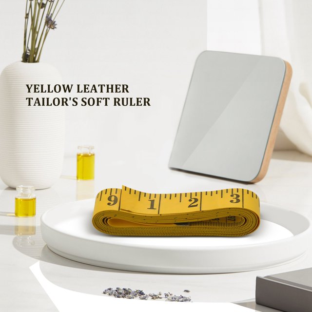 120 inch tape measure rule of tailor, a flexible yellow and black plastic measuring tool with large, easy-to-read markings. Measures up to 120 inches on one side and 300 cm on the reverse. Suitable for sewing, crafts, and scientific projects. Displayed coiled on a white tray in a minimalist setting.