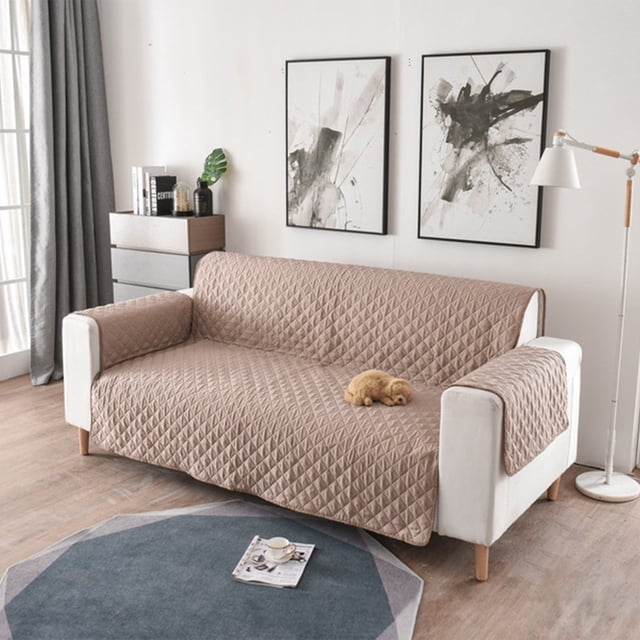 LSLJS Housse de Canapé Réversible pour Coussin Housse de Sofa pour Chiens, Montrée dans un design Matelassé beige. la Housse Est Résistante à l'Eau et Comprend des Bâtons en Mousse et des Sangles Élastiques pour la Fixer en place. Elle Protège les Meubles contre les Déversements, les Taches et l'Usure des Animaux. le Sofa Est Placé dans un Salon Moderne avec une Oeuvre Murale Abstraite, une Lampe sur Pied et un Rideau Gris.