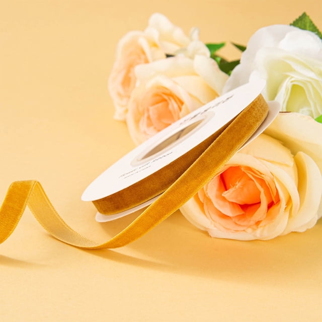 Meitianfacai 1cm single-sided velvet ribbon in gold, displayed on a spool with a soft velvet texture. Surrounded by pastel-colored roses on a warm yellow background, this ribbon is ideal for arts and crafts, holiday decorations, gift wrapping, and DIY flower arrangements.