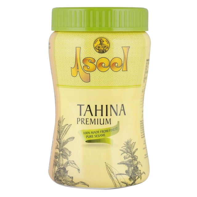 ASEEL Pot TAHINA premium avec Couvercle Vert à Vis et Étiquette Jaune Affichant le Nom de Marque « ASEEL » et « 100 % Fait de Sésame Pur de la Meilleure Qualité », avec illustrations Botaniques, Idéal pour les Recettes Alimentaires du Moyen-Orient et les sauces tahini.