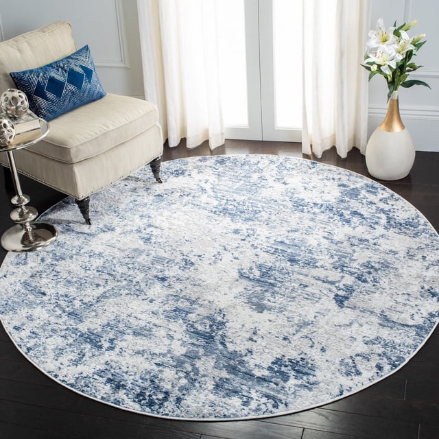 SAFAVIEH Amelia Alastar Abstract Distressed Area Rug, round with a plush textured finish in blue and white abstract distressed pattern, placed on dark hardwood flooring beside a beige armchair with a blue geometric pillow and a silver side table, near sheer white curtains and a white vase with lilies, ideal for living rooms or bedrooms.