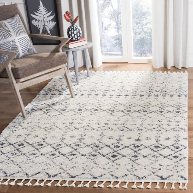Safavieh Berber Fringe Lesleigh Aztec Shag Tapis de 1,25 Po à Poils Pelucheux, avec Motifs Tribaux Aztèques Blancs et Noirs et Bords à Franges, Posé sur Plancher de Bois Franc à Côté d'Un Fauteuil en Bois et d'Une table d'Appoint, Convient pour Ajouter une texture Bohème aux Salons.