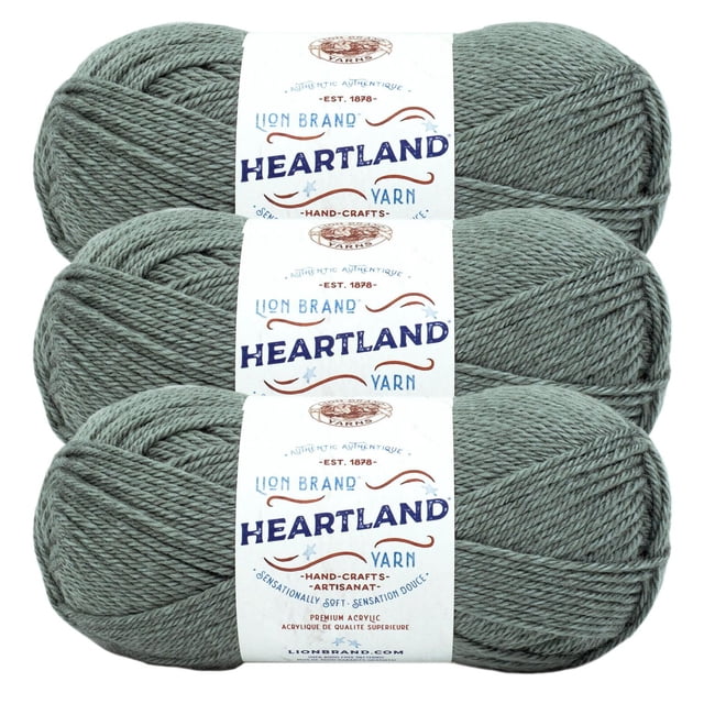 Lion Brand Yarn Heartland Yarn 3Pack featuring three skeins of medium worsted weight acrylic yarn in muted green, each with a white label displaying blue and brown vintage text, suitable for knitting and crochet projects and machine washable for easy care.