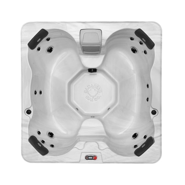 Cornwall 6-Person Plug & Play Spa with white marble-patterned shell, deep corner seating, and two elevated middle seats, featuring 18 adjustable hydrotherapy jets, black headrests, and an embossed Canadian Spa Company logo. Includes Glacier filtration with silver ion technology and ozone generator for clear water, top-down view.