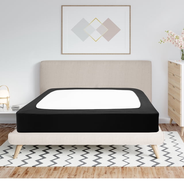 PiccoCasa Box Spring Cover Wrap Around 4 Sides in black, shown on a queen-sized mattress in a modern bedroom setting. The smooth, stretchy cover fits tightly on mattress depths from 8 to 14 inches, providing a clean and wrinkle-free finish. Made of 95% polyester and 5% spandex, it is breathable, durable, and machine washable. The cover enhances the bed's appearance by hiding the box spring and adding a touch of elegance.