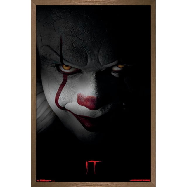 IT - Pennywise Affiche Murale, Affiche Encadrée 22,375 Pouces x 34 Pouces avec Fond Noir et Texte « IT » Rouge Près du Bas, Encadrée dans un Cadre en Bois Brun, Convient à la Déco de la Maison et à l'Art Mural.