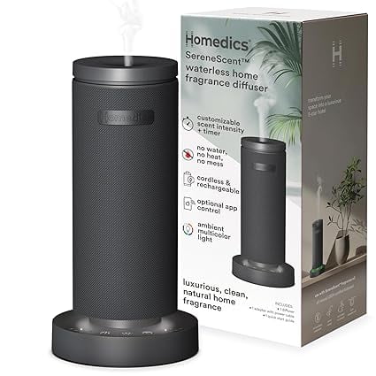 Homedics SereneScent™ Waterless Rechargeable 15 ml Bluetooth Diffuser in black, featuring a sleek cylindrical design with a textured surface. The diffuser is displayed on a round base with a mist emitting from the top. The packaging in the background highlights features such as customizable scent intensity, cordless and rechargeable functionality, and ambient multicolor lighting. Ideal for smaller spaces like bathrooms or apartments, it uses natural fragrance oils (sold separately) and operates without water or heat.