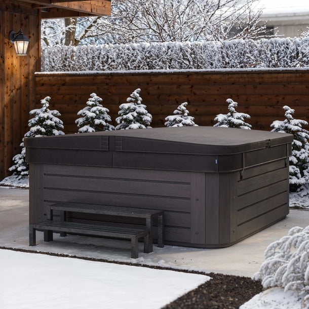 Custom Hot Tub Cover with 5-inch to 3-inch tapered thickness shown on a hot tub in a snowy outdoor setting. The cover is made of durable, UV-resistant vinyl, designed to withstand Canada’s harsh winters. It features a snug fit, moisture runoff design, and energy-saving insulation. Available in multiple colours and materials, including marine-grade vinyl and WeatherShield™ PRO-TEX fabric. Compatible with all hot tub brands and models.
