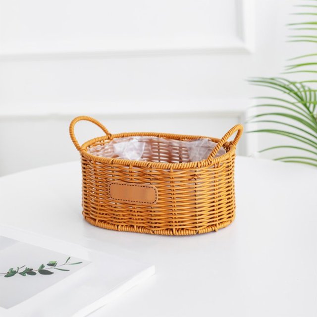 TopLLC Imitation Rattan Flower Basket Woven Flower Pot Double Ear Oval Storage Basket. This yellow, oval-shaped basket is made from durable imitation rattan plastic with double ear handles for easy carrying. It features a woven design and a lined interior, suitable for flower arrangements, home storage, or as a decorative gift basket. Measuring 17 x 10.5 x 7.5 cm, it is lightweight and easy to clean, making it ideal for dorms, RVs, or home offices.