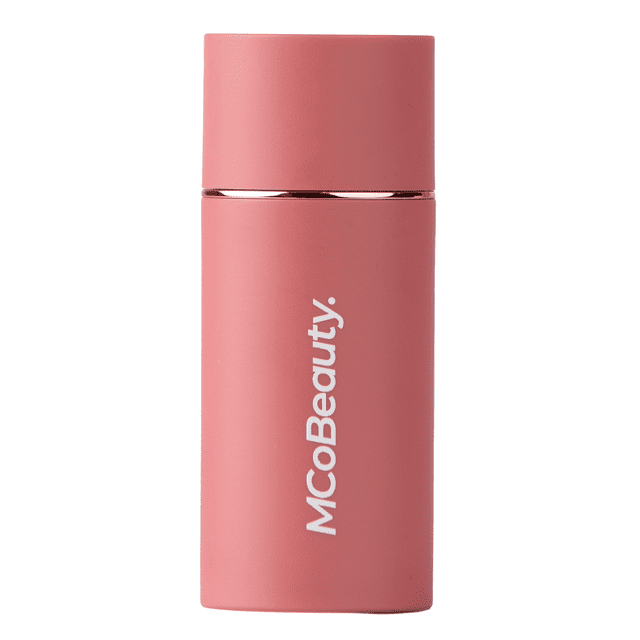 MCoBeauty Baby Face Multi-Use Cream Stick in creamy blush shade, shown front-facing in a matte pink cylindrical container with white brand text, featuring a blendable formula with jojoba and coconut oils for a natural radiant glow on cheeks and lips.