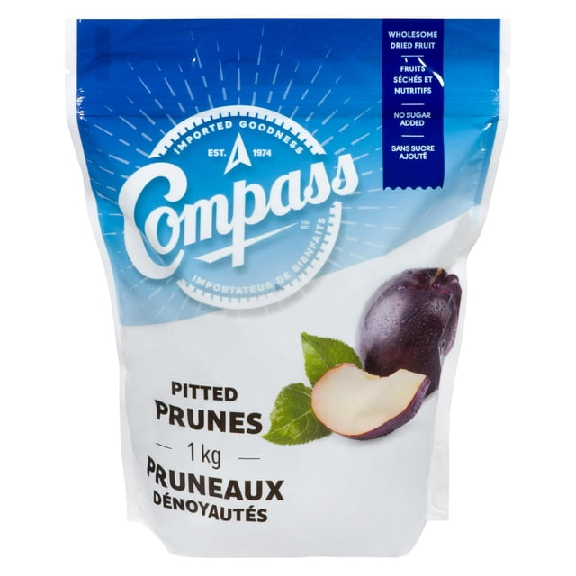 Compass Pitted Prunes 1 kg bag with blue and white packaging featuring the Compass logo and images of a whole and halved prune with green leaves, labeled as wholesome dried fruit with no sugar added, suitable for cereals, salads, yogurt, or trail mixes.