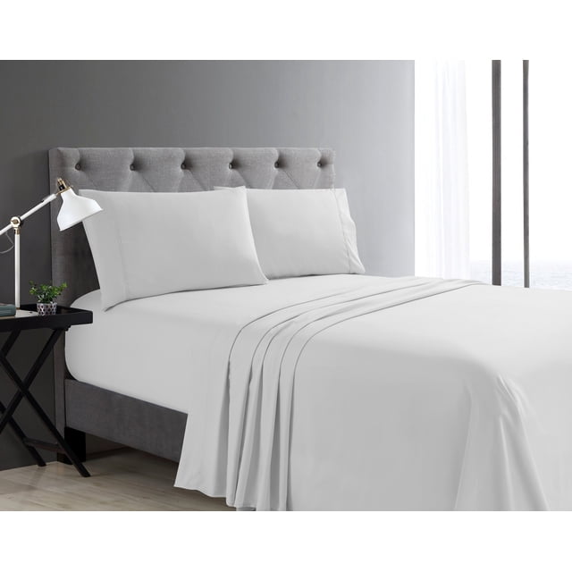 Swift Home Basic 4-Piece Double Size Sheet Set in white on a bed with a grey tufted headboard, featuring a deep pocket fitted sheet for mattresses up to 16 inches, flat sheet, and two pillowcases made of ultra-soft, breathable fabric, displayed in a minimalist bedroom with a black nightstand, white lamp, and sheer curtains.