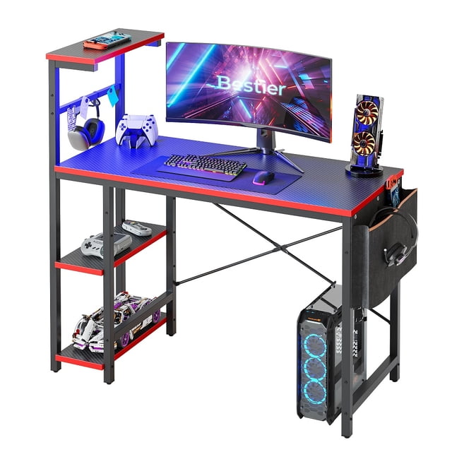 Bestier Reversible 44 inch Computer Desk with LED Lights and 4 Tier Shelves Gaming Desk. This black gaming desk features a spacious desktop for monitors, PCs, laptops, and accessories. It includes RGB LED lighting with 7 colours and 20 dynamic settings, a headphone hook, a side pocket storage bag, and three adjustable open shelves. The reversible shelf can be installed on either side, and the desk is supported by a durable steel frame with an X crossbar for stability. Suitable for home offices, bedrooms, dorms, or gaming setups.