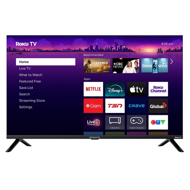 Magnavox 32” 1080p Full HD QLED Roku Smart TV, Black front-facing 32-inch flat-screen with slim black bezel showing the Roku home screen; QLED quantum dot panel for broad colour range and Full HD 1920x1080 clarity, 16:9 aspect, tabletop stand and HDMI input visible — often used in small living rooms or dorm rooms.