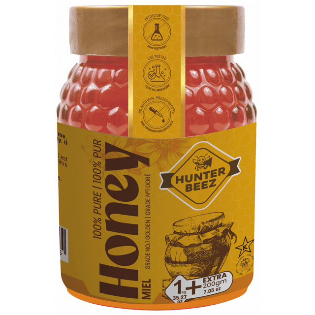 Hunter Bee Natural Honey 1KGx2 jar containing golden honey in a textured honeycomb-patterned plastic container with a brown lid. The label indicates 100% pure honey, pesticide-free, lab tested, no artificial preservatives, and net weight of 1 kg plus 200 gm extra, ideal for pantry storage.