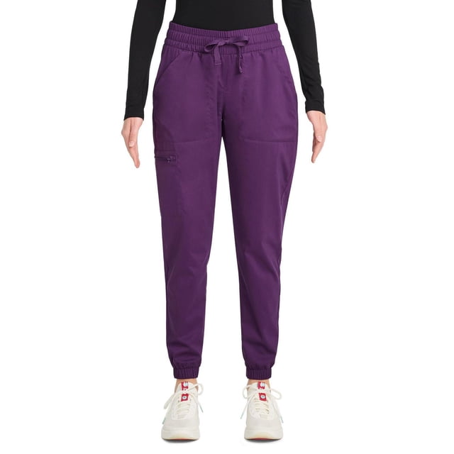 Scrubstar Pantalon de Sarrau Cargo Jogger à Cordon pour Femmes Ultimate Stretch WC047A en Violet avec Jambes Fuselées avec Poignets Élastiques, Taille à Cordon Ajustable et Cinq Poches Spacieuses, Dont une Poche Cargo Zippée, Montré à l'Avant avec des Espadrilles Blanches et un Haut à Manches Longues Noir, Idéal pour un Confort Toute la Journée en Soins de Santé Ou en Milieux de Travail.