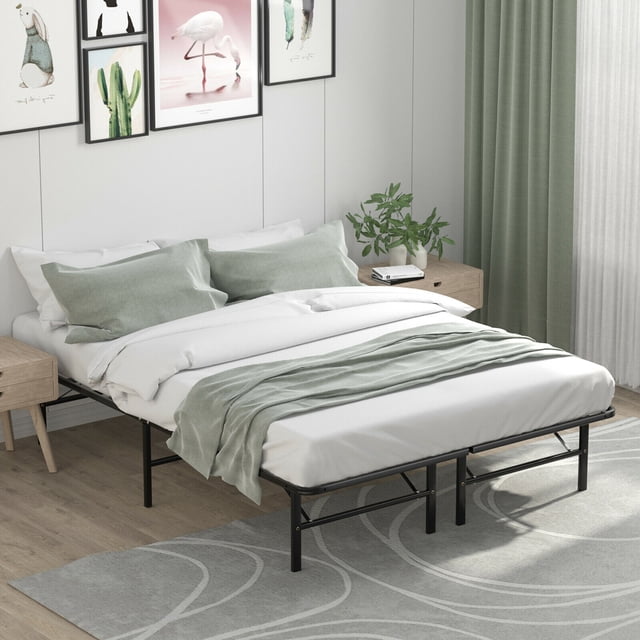 Gymax 14'' Queen Size Metal Platform Bed Foldable Mattress Foundation with tool-free assembly, shown in a modern bedroom setting. The black powder-coated steel frame supports a neatly made bed with white bedding and green accents. Spacious under-bed storage is visible, ideal for boxes or luggage. Its foldable design makes it suitable for compact storage in small spaces.