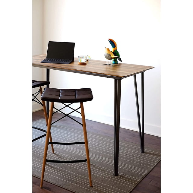 Inspirer Studio Bar Table Set, a modern pub-style counter height dining table with a rustic brown rectangular MDF tabletop and black steel trestle base. Ideal for kitchen counter height dining or industrial decor settings, shown with stools and decorative items in a minimalist dining area.