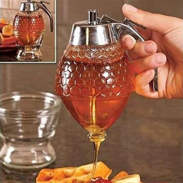 Reweti Clearance 1PCS Syrup and Juice Dispenser Honey Syrup Dispenser Honey Pot Pulp Juice Dispenser Honey Pot Press Honey Seasoning Bottle Easy Honey Dispenser Kettle. A transparent acrylic honey dispenser with a honeycomb texture, designed for kitchen organization and food storage. It features a press-release handle for controlled dispensing and is shown pouring honey onto waffles, with a glass container and fruit in the background.