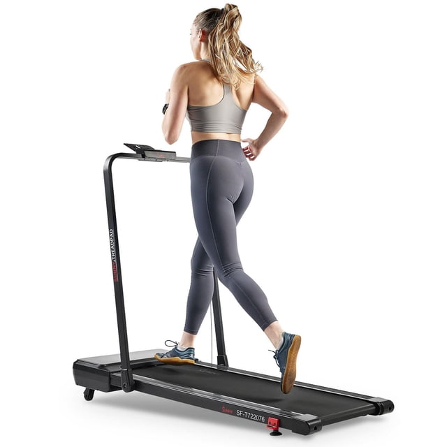 Sunny Health & Fitness Treadpad Pacer Dual Mode Walking/Running Treadmill with 6-Level Auto Incline, showing a woman running on the compact black treadmill with a slim frame and digital console, designed for indoor cardio workouts with Bluetooth app connectivity and adjustable incline.