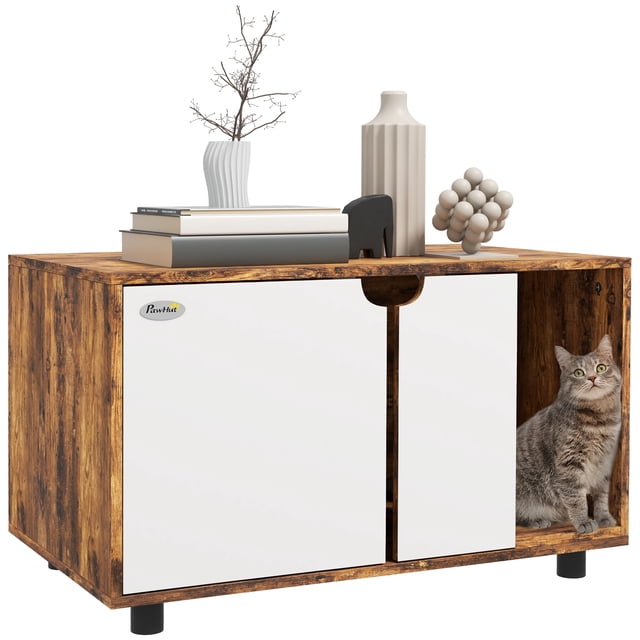 PawHut Enclos Caché pour Litière de Chat avec Tapis d'Évacuation de Sable en Brun Rustique, Présentant un design à double Usage comme Meuble Télé Élégant et Bac à Litière pour Chat. l'Enceinte a des Portes Doubles Blanches avec une Découpe pour un Accès Facile et un Tapis d'Évacuation de Sable pour Réduire le Suivi de la Litière. un Chat Tigré Gris Est visible à l'Intérieur du Compartiment Droit. la surface Supérieure Est Décorée de Livres, de vases et d'Ornements, s'Intègre Sans Couture à la Déco de la Maison.