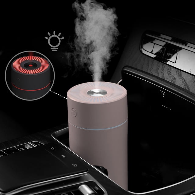 Portable Mini Humidifier for Bedroom, Office & Nursery - 320ml Cool Mist Humidifier shown in a pink color option, placed in a car cup holder. The humidifier emits a visible mist and features a circular vented top with a power button on the side. An inset image highlights the LED night light feature in red. Ideal for quiet operation (<18dB) and equipped with two spray modes, auto shut-off, and a colorful LED night light.