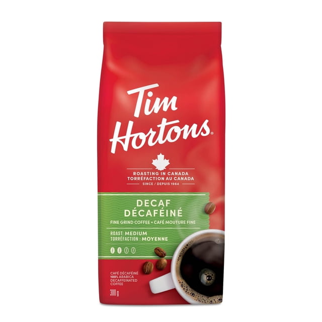 Tim Hortons Fine Grind Decaffeinated Coffee 300g bag with red and green packaging featuring the brand name, Canadian maple leaf logo, medium roast label, and a white cup of black coffee with crema, ideal for use in automatic filter coffee makers.