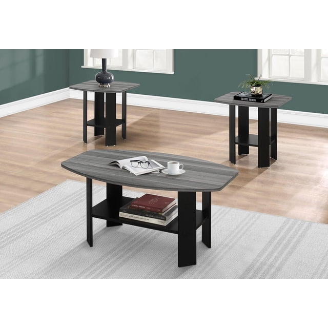 Monarch Specialties Table Set, 3-piece living room set with a coffee table and two end tables, featuring black frames and grey wood-look laminate tops with modern angled legs and open lower shelves for storage, shown in a bright room with hardwood floors and green walls. The set is also suitable for organizing magazines or decorative items.