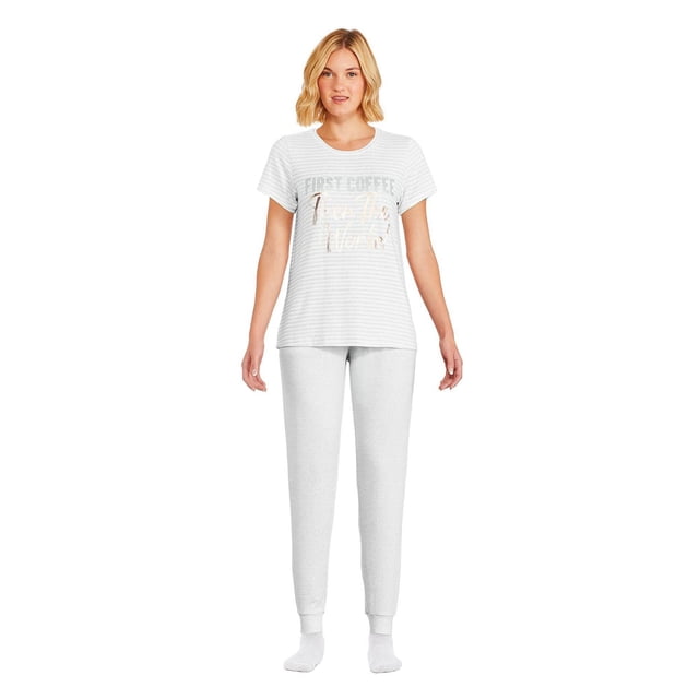 George Pyjama Hacci pour Femme, Ensemble 2 Pcs avec Vue avant d'Une Femme Portant un T-Shirt Gris à Manches Courtes Col Ras du Cou avec un « D'abord Café, Puis Adulte » Graphique et de Subtiles Rayures Horizontales, Assorti à un Pantalon jogger Hacci Gris en Tricot avec une Taille Élastique à Cordon et des Poignets Ajustés, Style avec des Chaussettes Blanches sur un Fond Blanc.