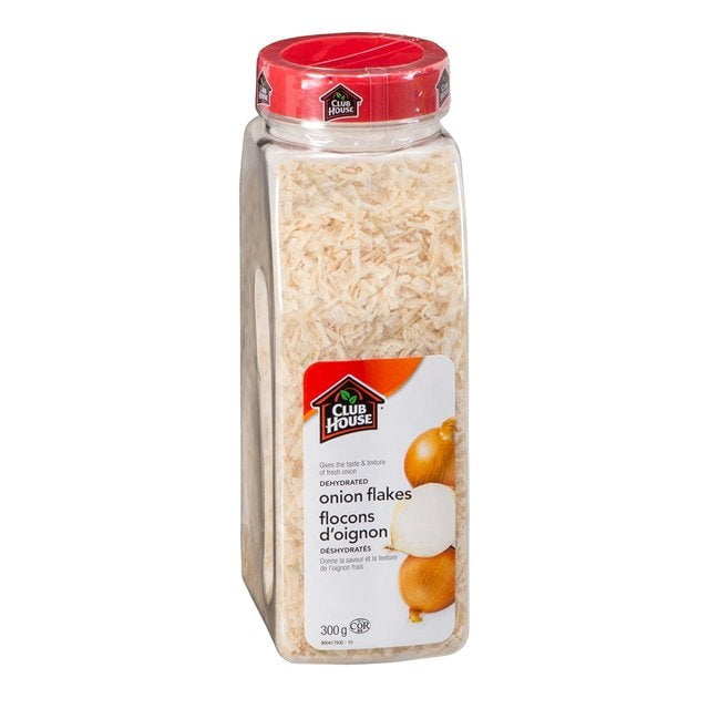 Clubhouse Dehydrated Onion Flakes in a 300g clear plastic container with a red lid, featuring a shaker, spoon, and pour cap. The label displays the Clubhouse logo, product name in English and French, and an image of onions. Ideal for seasoning and cooking, with 12 units per case.