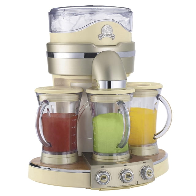 Margaritaville Tahiti Frozen Concoction Maker party-sized blender with three clear blending jars containing red, green, and yellow frozen drinks, cream and brushed metallic finish, bamboo base, ice reservoir with visible ice cubes, and control panel with three dials for pre-programmed settings.