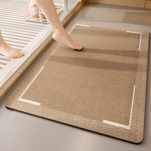 Dvkptbk Bath Mat Non Slip Floor Mat for Bathroom Entrance, featuring a beige textured surface with white corner accents. Designed for water absorption and slip resistance, it is shown placed near a shower area with a foot stepping onto it. Suitable for bathroom entrances, toilet areas, and as part of bathroom rug sets.