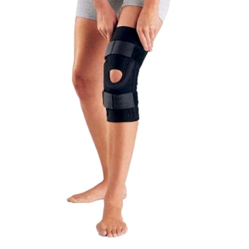 DonJoy Performer Genouillère Articulée pour Rotule - TTG Montrée Portée sur une Jambe. l'Attelles de Genou en Néoprène Noir Comprend des Sangles Cuisse et Mollet pour une compression Accrue, un Coussinet en Fer à Cheval Cousu pour le Soutien de la Rotule, et des Charnières à Double Axe en Aluminium Amovibles pour la Stabilité. Convient aux Douleurs Ligamentaires Articulaires Légères à Modérées, Entorses, Souches, Osgood Schlatter disease Ou Instabilités Rotuliennes.