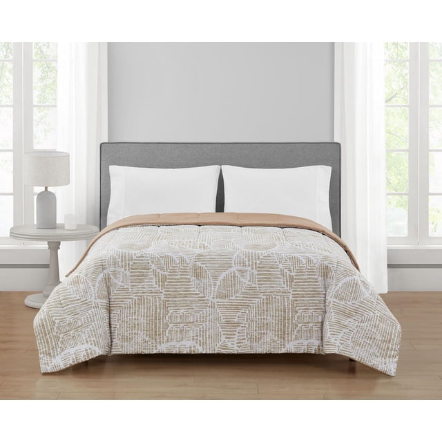 Mainstays Couette Paloma Double/Grand sur un Lit avec une Tête de Lit Rembourrée Grise, Présentant une Couette en Microfibre polyester à Motif Géométrique beige et Blanc avec un Côté beige Uni Réversible, dans une Pièce Lumineuse avec des Rideaux Blancs et une table d'Appoint Ronde avec une Lampe, Idéale pour un Style de Chambre Contemporain.