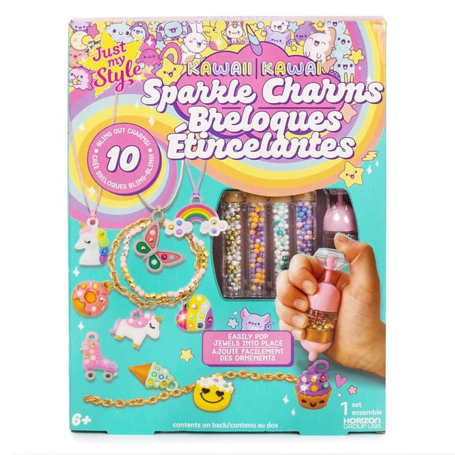 Just My Style Kawaii Sparkle Charms jewelry making kit includes 10 kawaii-themed charms such as unicorn, butterfly, rainbow, cupcake, and smiley face, a gold chain bracelet, assorted pastel faceted beads, and a pink jewel-placing pen held in hand for easy gem application, perfect for DIY charm bracelets for kids aged 6 and up.