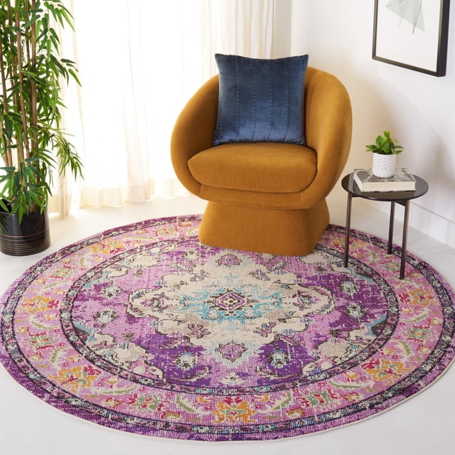 SAFAVIEH Monaco Toria Tapis Traditionnel de Forme Ronde avec des Motifs Vibrants d'Inspiration Persane Violet, Rose, Crème et Bleu, Fabriqué en pile de Polypropylène durable, Montré sous un Fauteuil Courbé Jaune Moutarde avec un Coussin Bleu, à Côté d'Une table d'Appoint Noire avec une Plante et des Livres dans une Pièce Lumineuse avec des Rideaux Blancs et une Plante en Pot Verte. le design Bohème Chic du Tapis Convient pour Ajouter de la Couleur et de la texture aux Espaces de Vie.