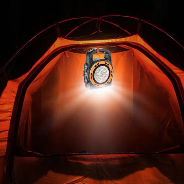 Dvkptbk Camping Lampe Projecteur Multifonction avec Lampe de Poche à Lumière Puissante et Lampe portable COB, Montrée à l'Intérieur d'Une Tente de Camping orange. la Lampe Présente un Corps en ABS orange et Noir avec une Poignée, Émettant une Lumière Vive Idéale pour le Camping, la Randonnée et les situations d'Urgence. Alimentée par une Recharge Solaire et USB, Elle Comprend un Câble USB et Sert de Chargeur d'Appareil d'Urgence. Conception Étanche avec 76 DEL et une Batterie de 2400 mAh Offrant 5-8 Heures d'Éclairage